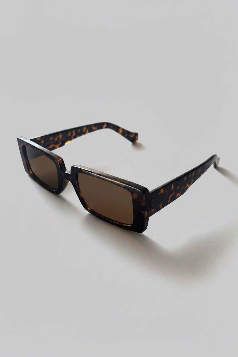 Sunglasses with tortoiseshell frame on a light gray background