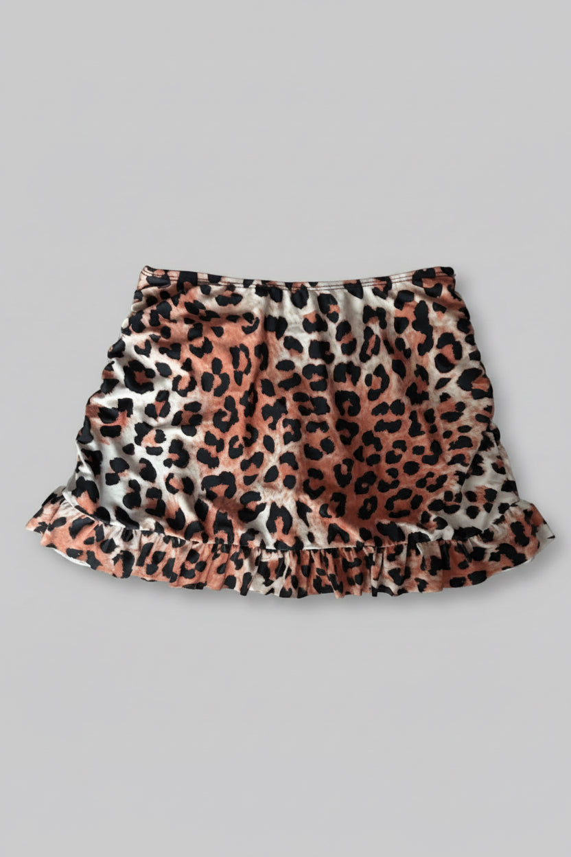 A ruffled mini skirt with a leopard print pattern shown flat against a solid grey background.