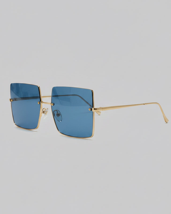 Sunglasses with blue lenses and gold frame on a light gray background