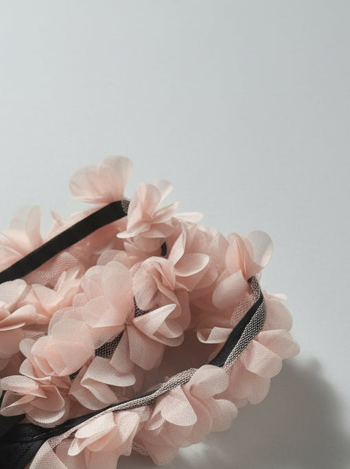 Close-up shot of the tulle flowers on the backless black Wifey swimsuit by eau archives