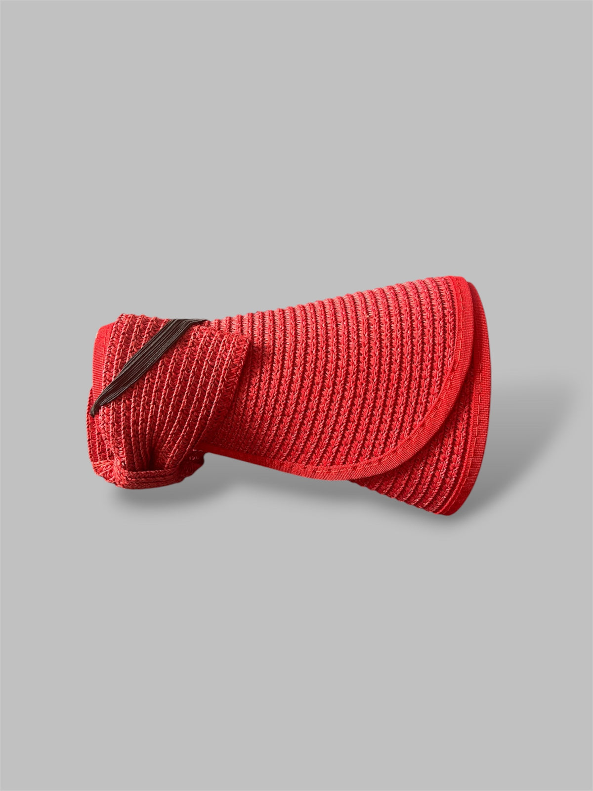 Red straw brim hats rolled up on a gray background