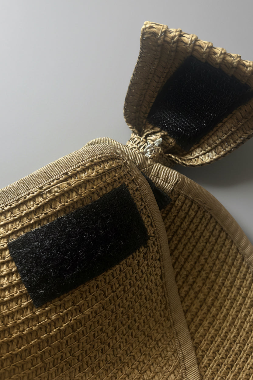 Close-up of a brown straw visor of the Velcro strap on a gray background