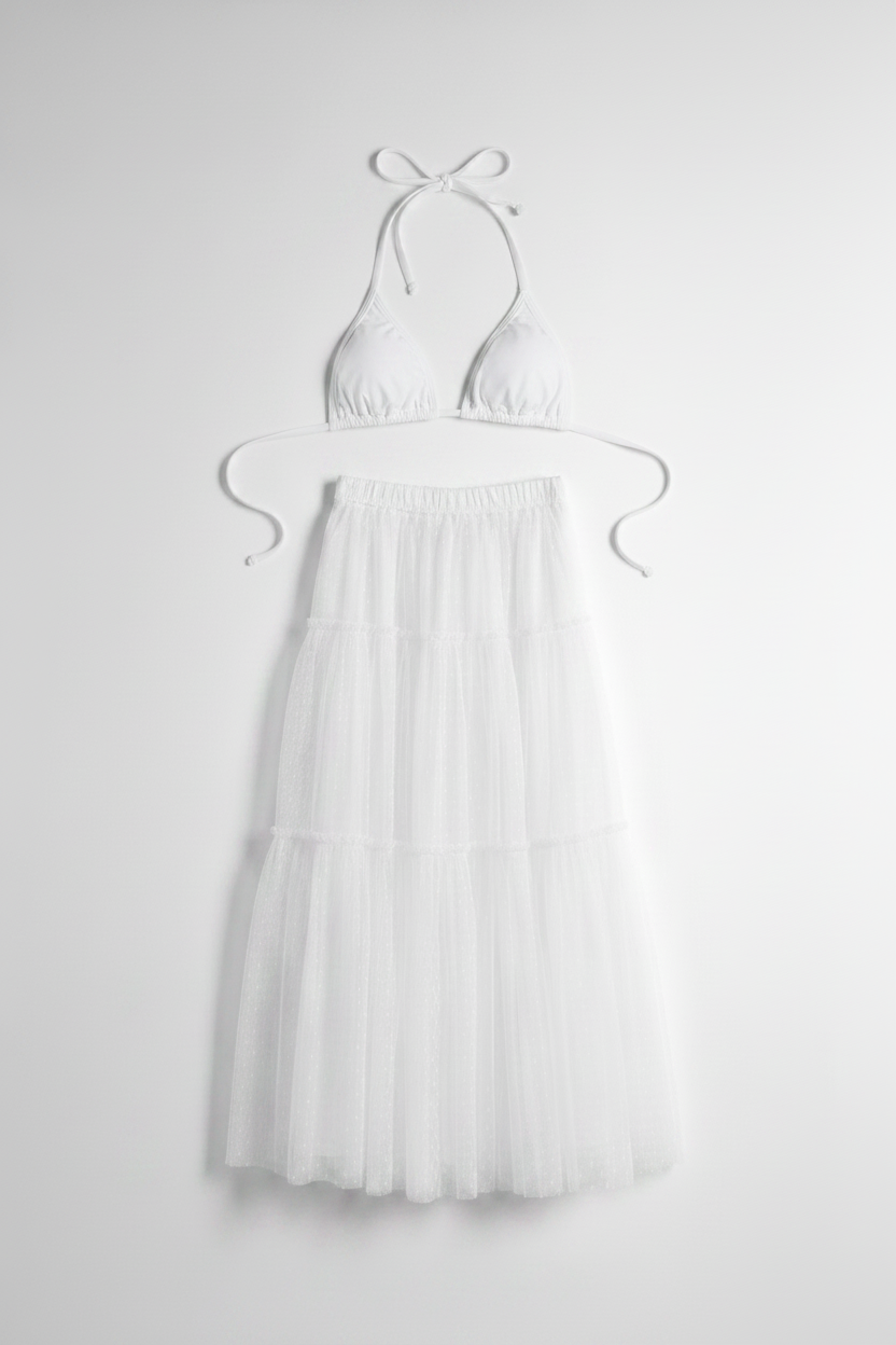 Full-length view of the voluminous Isabella tulle maxi skirt by eau archives pared with a white bikini top