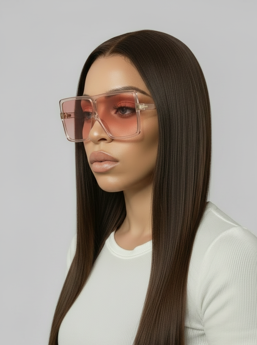 Woman wearing large pink sunglasses against a gray background