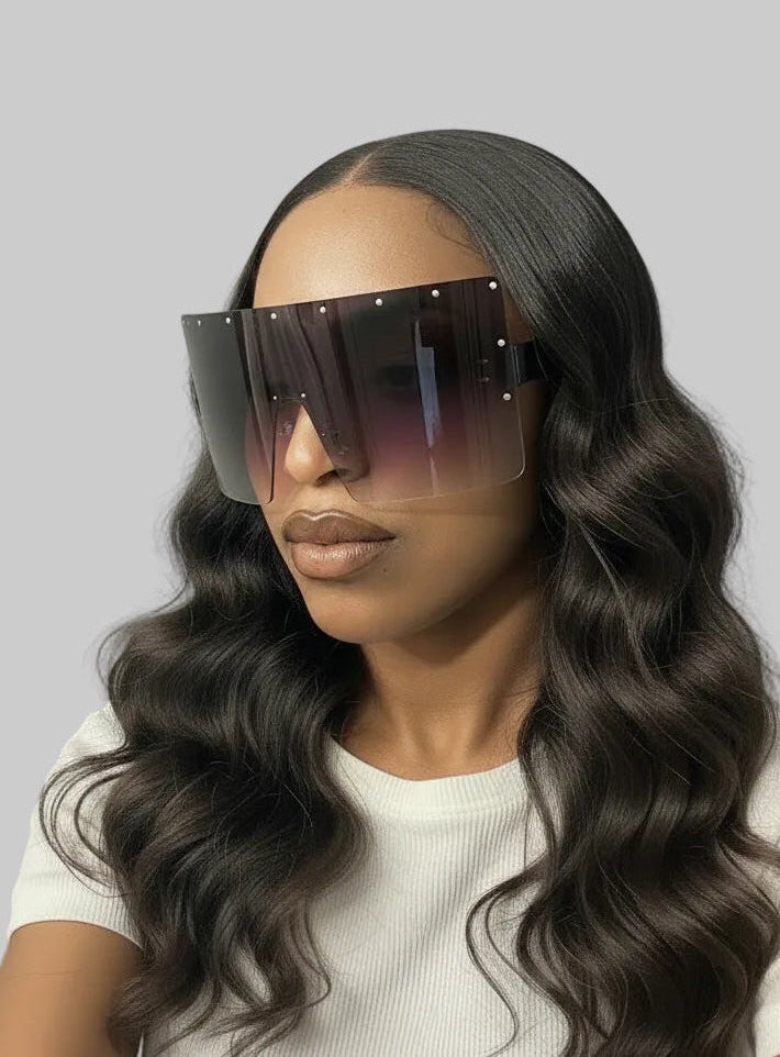 Woman wearing oversized rimless sunglasses with a plain background